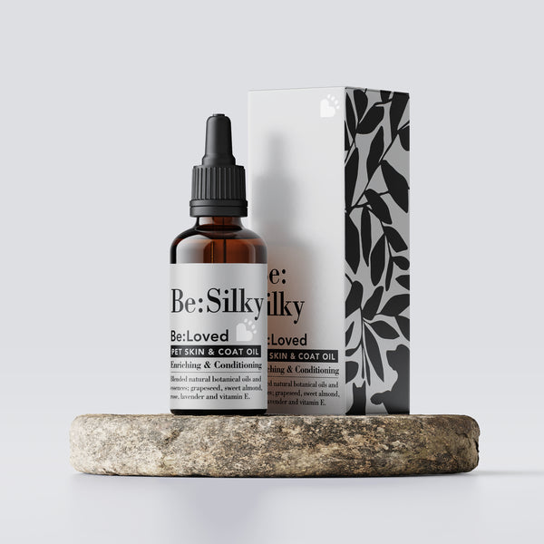 Be:silky pet skin and coat oil, inner and outer packaging on a wooden tray.